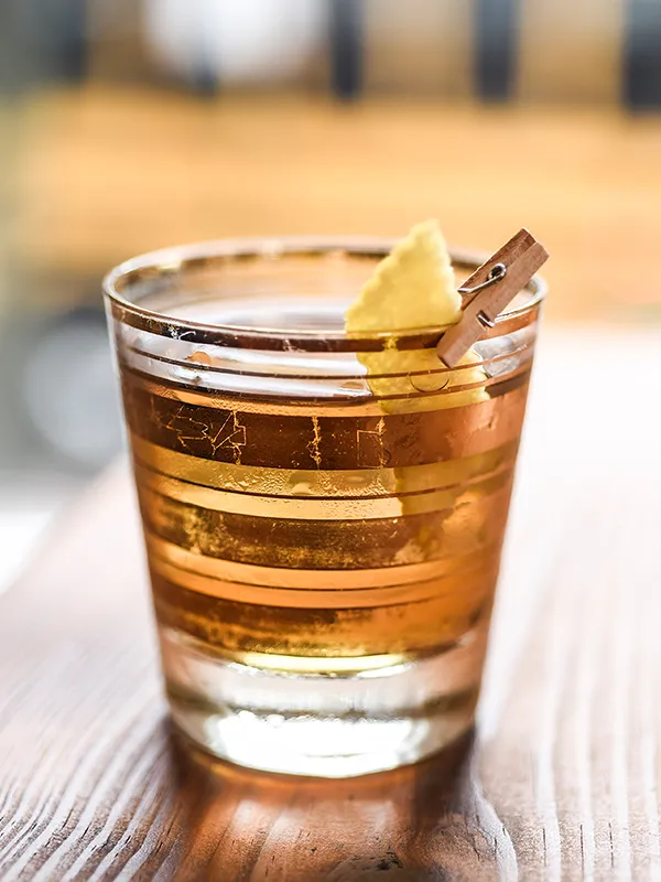 A gin cocktail with a lemon twist on a wooden bar at Dutch Courage